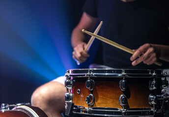 Close-up shot of a drummer playing a snare drum with sticks.