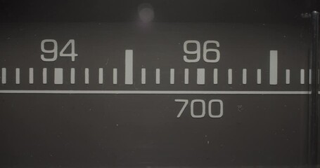 Radio Frequencies 96 MHz / 700 KHz. Macro extreme close up on a vintage silver brushed metal stereo system as the tuner dials to search for radio stations in the 96 MHz / 700 KHz range.