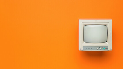 Vintage TV on an orange background. Space for the text. Flat lay.