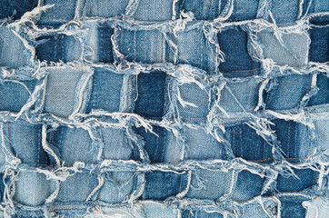 Surface of pieces of old tattered denim close