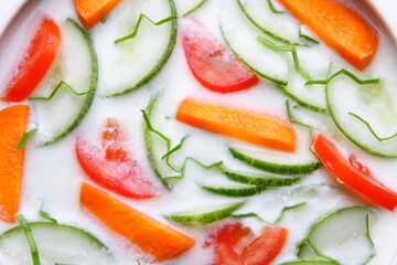 Bowl of delicious and healthy vegan diet food- organic cucumber, carrot, onion, tomato salad with curd, 