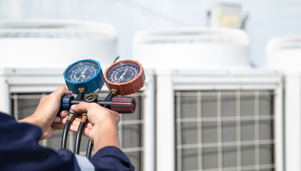 Technician is checking air conditioner ,measuring equipment for filling air conditioners , service and maintenance air conditioner .