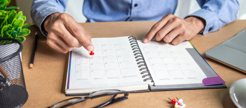 Businessman agenda calendar and reminder agenda work online at home men plan daily appointments and vacation travel journals in a diary at their desk . calendar reminder event concept .