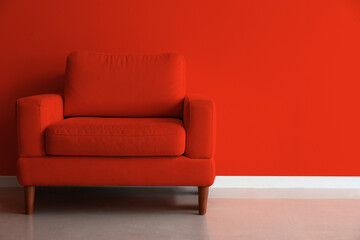 Comfortable armchair near red wall