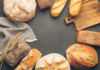 Frame made of different fresh bread on dark background