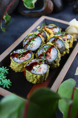 Japanese rolls in batter. Rolls in tempura with smoked salmon and green onions. Traditional Japanese cuisine. Vertical photo.Out of focus. View from above. Close-up.