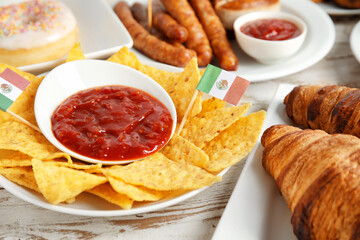 Plates with traditional food of different countries on wooden background