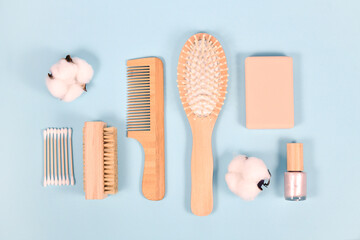 Eco friendly wooden beauty and hygiene products like comb and soap on blue background