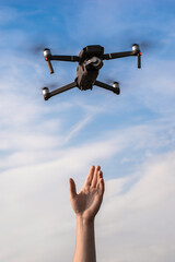 a tourist guy launches a quadrocopter and reaches for it with his hand