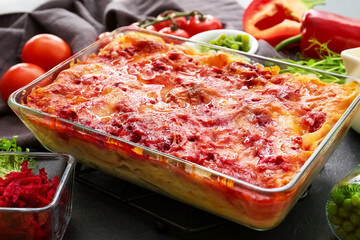 Baking dish with tasty vegetable lasagna on table