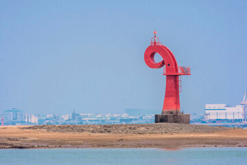 Red lighthouse in Dangjin harbor in South Korea at low tide.