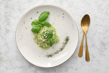 Plate with tasty pesto pasta on light background