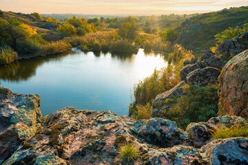 A small pile of stones in a green-yellow field against the background of sky in beautiful Ukraine