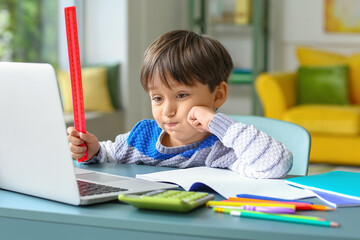 Little boy tired of studying online at home