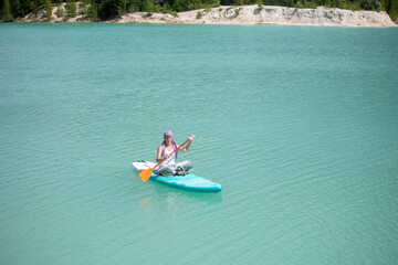 The girl does yoga on the glanders on the pond