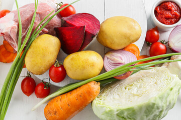 Ingredients for preparing tasty borscht on white wooden background, closeup