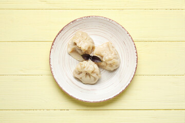 Plate with tasty dumplings on color wooden background