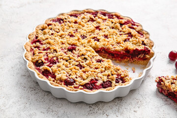 Baking dish with tasty cherry pie on light background, closeup