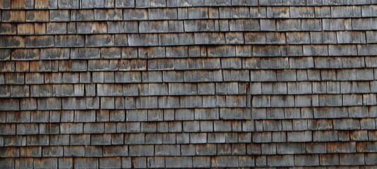 a house wall covered with small wooden tiles as a background
