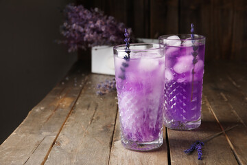 Glasses of fresh cocktail with lavender on dark wooden background