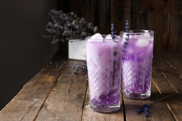 Glasses of fresh cocktail with lavender on dark wooden background