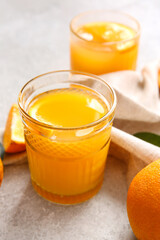 Glass of tasty orange juice on light background, closeup