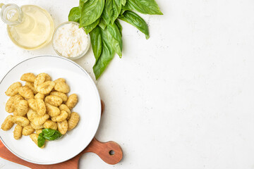 Composition with tasty pesto gnocchi on light background