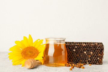 Jar with honey and beebread on light background