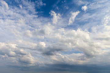 Fototapeta na wymiar Cielo azzurro , in pianura, con nuvole bianche e grigie che annunciano la pioggia in estate. 