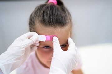 Applying Band Aid To Children Wound