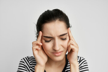 sick woman in a striped t-shirt pain in the neck light background