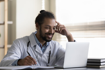 Happy millennial male african american multiracial gp doctor therapist physician watching medical...