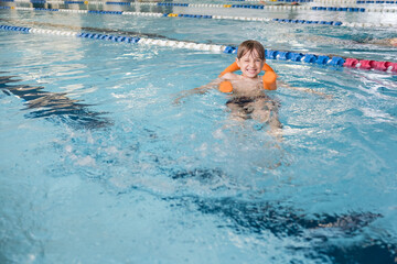 The boy learning to swim in the indoor pool
