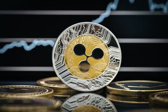 Ripple XRP cryptocurrency, physical coin close-up in front of a price chart