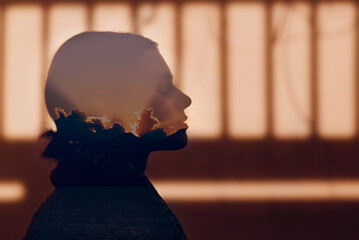 Double exposure portrait of beautiful woman with sunset in her head.