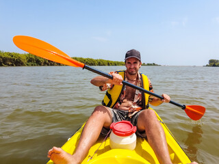 A young man in the canoe doing canoeing in the a natural park of Catalonia, river next to the beach in Estartit