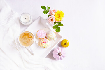 Cup of coffee, pink pumpkins, roses bouquet, cupcakes on the white background. Feminine atmosphere. Woman power. Happy Halloween. Girlish fall composition. Coffee break at home. Holiday girly concept.