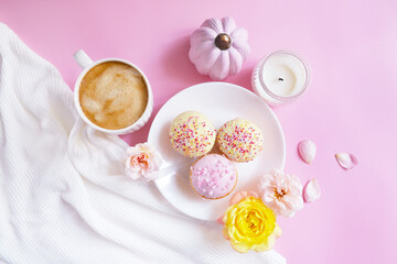 Cup of coffee, pumpkins, roses, cupcakes on the pink background. Feminine autumn atmosphere. Woman power. Happy Halloween. Girlish food composition.  Woman's power card. Coffee break at home 