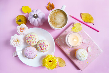 Fototapeta na wymiar Cup of coffee, pumpkins, roses, cupcakes, yellow leaves on the pink background. Feminine autumn atmosphere. Woman power. Happy girlie Halloween. Girlish fall composition. Hello autumn woman's card. 
