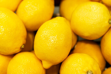 Lots of lemons in a box. Juicy ripe product. Vitamins and antioxidants from nature. Close-up.