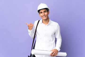 Young architect man isolated on background pointing to the side to present a product