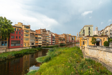 Fototapeta na wymiar Girona medieval city, traditional colored houses on the Onyar river, Costa Brava of Catalonia in the Mediterranean. Spain