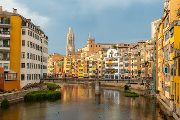 Girona medieval city, basilica and the cathedral next to the colored houses on the Onyar river, Costa Brava of Catalonia in the Mediterranean. Spain