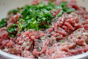 Homemade minced meat for cutlets with parsley in a bowl for cooking