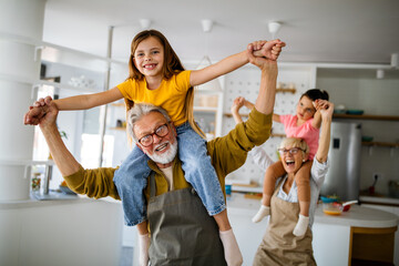 Grandchildren having fun at home while playing with their grandparents - obrazy, fototapety, plakaty
