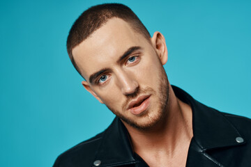 handsome man short haired leather jacket close-up blue background