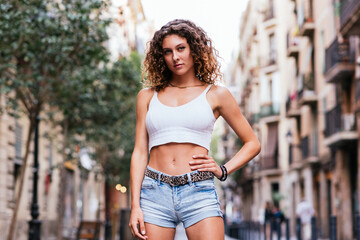 Obraz na płótnie Canvas horizontal portrait of a beautiful caucasian young woman standing in a street of Barcelona