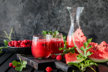 Summer drink. Cold watermelon juice with lime and mint on a wooden board. Berry-fruit smoothie.