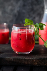 Summer drink. Cold watermelon drink with lime and mint on a wooden board. Berry-fruit smoothie.