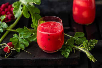 Summer drink. Cold watermelon juice with lime and mint on a wooden board. Berry-fruit smoothie.